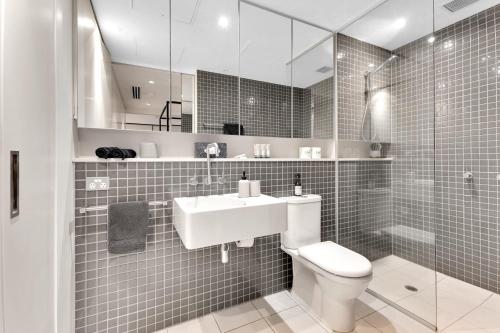 uma casa de banho com um lavatório, um WC e um espelho. em Opulent Level 25 Condo with Breathtaking Views em Melbourne