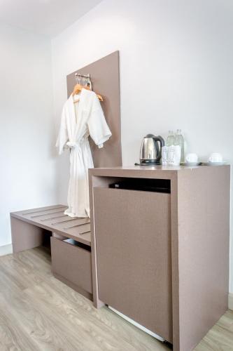 a white robe hanging on a wall next to a counter at Embryo Hotel  in Pattaya Central