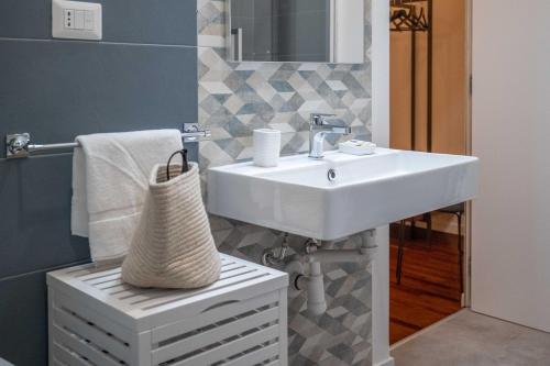 La salle de bains est pourvue d'un lavabo blanc et d'un miroir. dans l'établissement Costa Suites, à Palerme