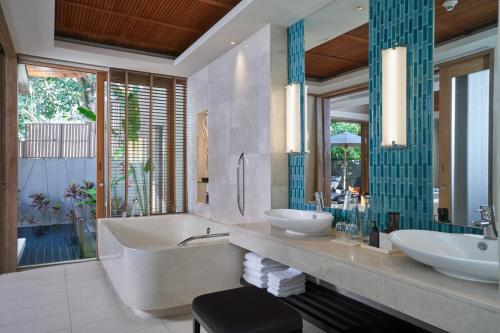 a bathroom with two sinks and a large mirror at Renaissance Phuket Resort & Spa in Mai Khao Beach