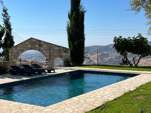 a swimming pool with lounge chairs next to a building at Romanos Villa in Paphos