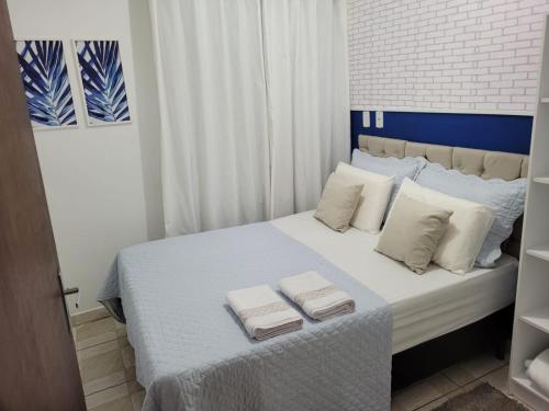 um quarto com uma cama com duas toalhas em Apartamento Aconchego Azul Pomerode em Pomerode