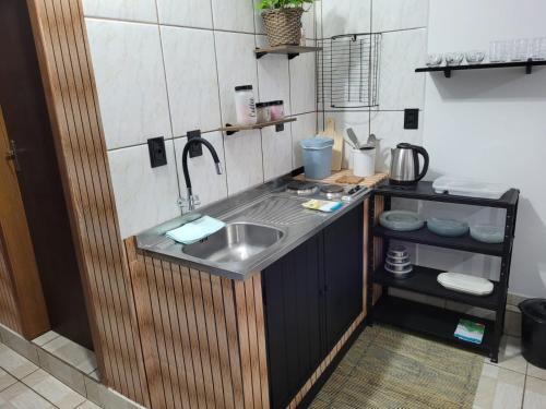 uma pequena cozinha com um lavatório e um balcão em Apartamento Aconchego Azul Pomerode em Pomerode