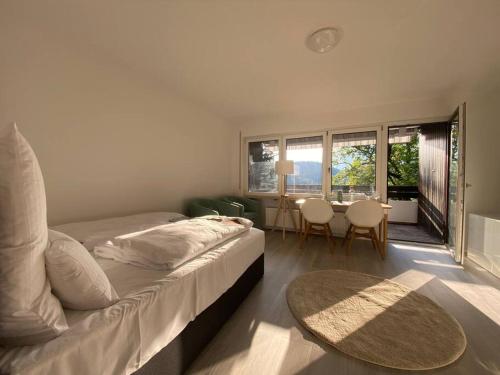1 dormitorio con 1 cama y 1 mesa con sillas en FeWo in ruhiger Aussichtslage, en Bad Liebenzell