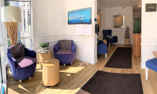 a living room with two chairs and a fireplace at Victoria Suites in Bad Saarow