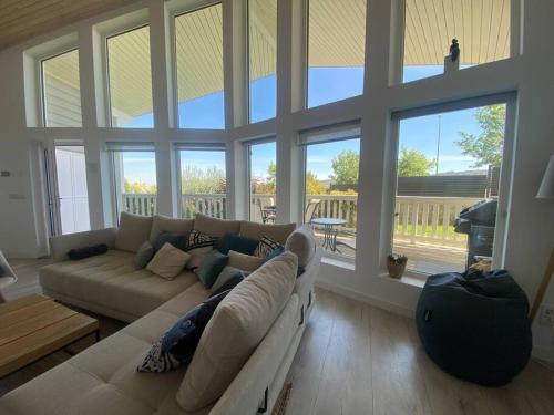 a living room with a couch and large windows at Casa Nunki in Guadalix de la Sierra