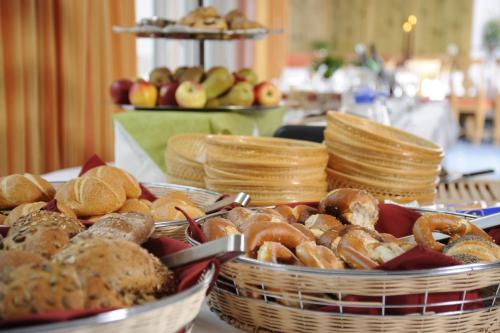 two baskets filled with different types of bread on a table at Parkhotel Altmühltal in Gunzenhausen