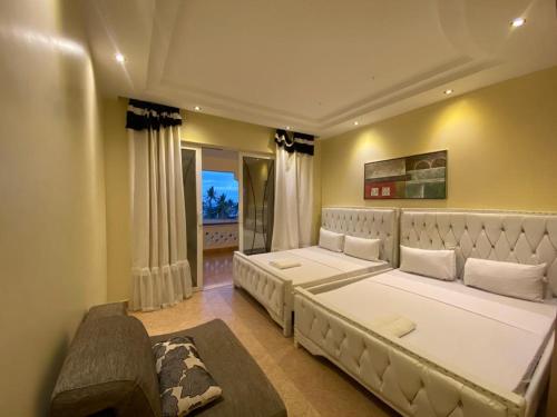 Un dormitorio con una gran cama blanca y una ventana en Lux Suites Shanzu Beachfront Apartments, en Shanzu