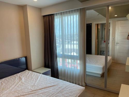 1 Schlafzimmer mit 2 Betten und einer Glasschiebetür in der Unterkunft SEVEN SEAS CONDO RESORT in Jomtien Beach