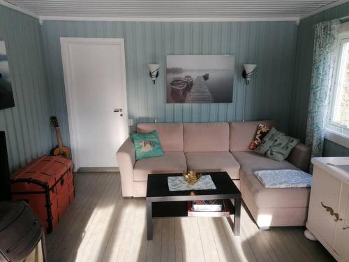 a living room with a couch and a table at Beautiful Lavangsnes, sea , private beach, boat. 