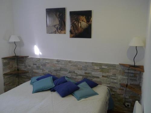 een slaapkamer met een bed met drie foto's aan de muur bij A ChiOsella Égée in Corbara