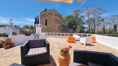 un patio avec des canapés et des chaises sur un toit dans l'établissement Happen!ng, à Faro