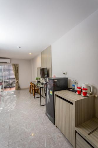 a kitchen with a refrigerator and a table in a room at Embryo Hotel  in Pattaya Central