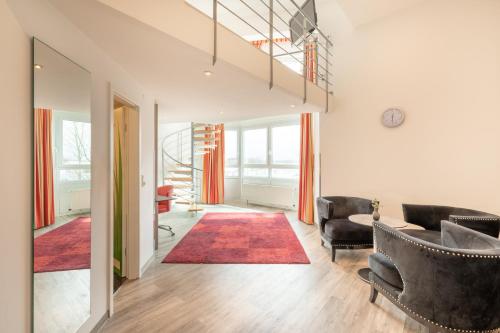 a living room with two couches and a red rug at Select Hotel A1 Bremen-Stuhr in Stuhr