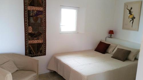 a bedroom with a bed and a couch and a window at Domaine de l'Envolée in Tourbes