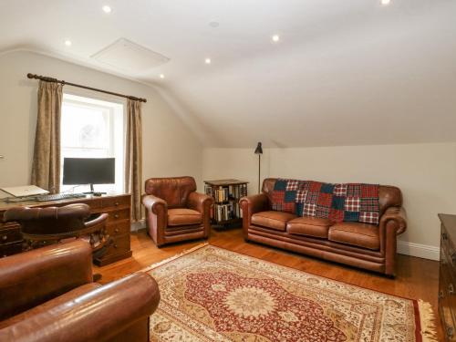 a living room with leather furniture and a television at Belle Vue in Hereford