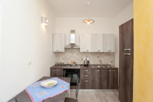una cocina con armarios de madera y una mesa con una placa. en Appartamento Irgoli - Sardegna, en Irgoli