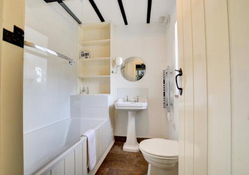 a white bathroom with a toilet and a sink at Calverts Nook in Hawes