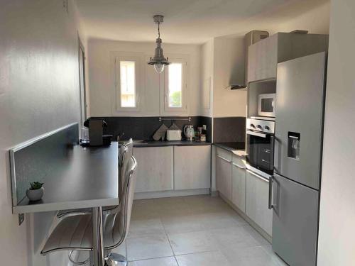 Il comprend une cuisine équipée d'un comptoir et d'un réfrigérateur. dans l'établissement Le St Martin, à Montpellier