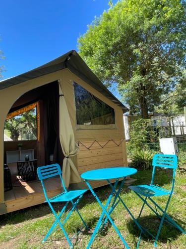 duas cadeiras e uma mesa em frente a uma tenda em Camping Beaussement Baroudeur em Chauzon