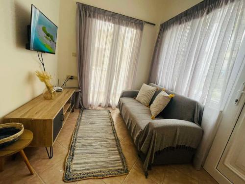a living room with a couch and a window at Ammoudeli Apartments in Plomarion