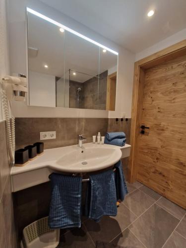 ein Bad mit einem Waschbecken und einem Spiegel in der Unterkunft Apart Kreuzspitz in Vent
