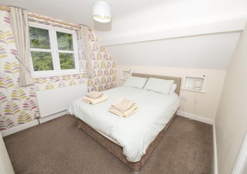 a bedroom with a bed with two towels on it at Call Out Cottage in Sledmere