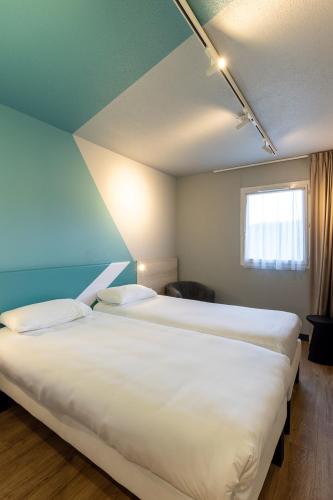 a bedroom with two large beds in a room at ibis Budget Millau Viaduc in Millau