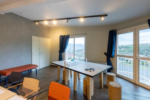 a dining room with a table and chairs and windows at ibis Budget Millau Viaduc in Millau