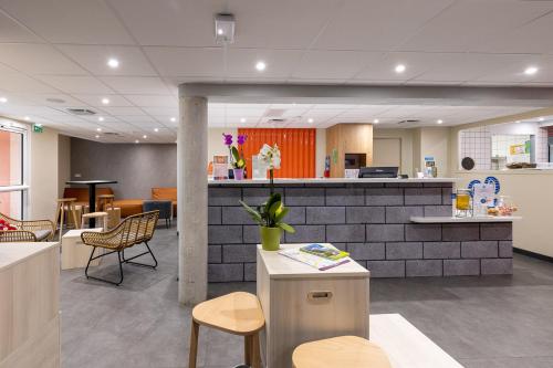 a lobby of a hospital with a counter and chairs at ibis Budget Millau Viaduc in Millau