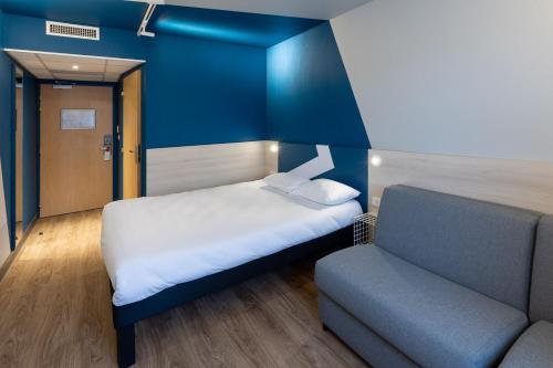 a small room with a bed and a couch at ibis Budget Millau Viaduc in Millau