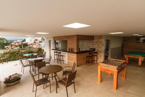 a room with tables and chairs and a pool table at Ville de Montagne Hotel in Brumadinho