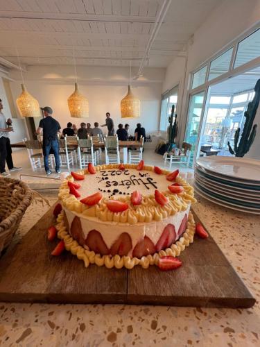a cake sitting on top of a wooden cutting board at Hotel La Potiniere in Hyères
