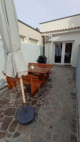 a patio with an umbrella and a table and bench at Caveromane 2 in Pula