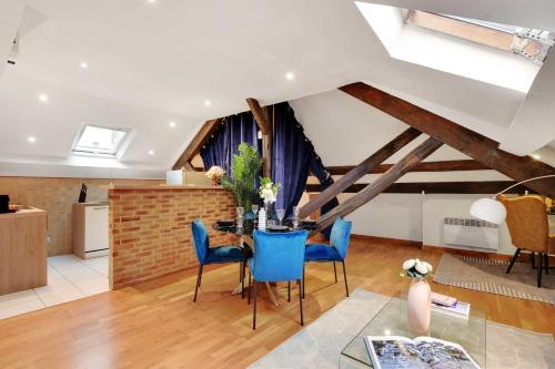 un salon avec une table et des chaises bleues dans l'établissement Comfortable apartment - 2BR-6P - Parc Monceau, à Paris