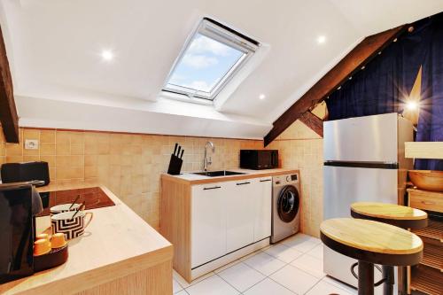 une cuisine avec un réfrigérateur blanc et une fenêtre dans l'établissement Comfortable apartment - 2BR-6P - Parc Monceau, à Paris