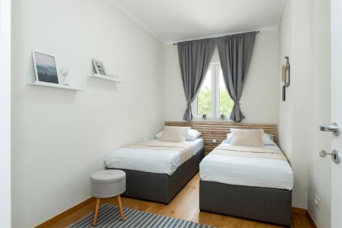 Un dormitorio con dos camas y una ventana. en Villa Niente da Fare, en Šibenik