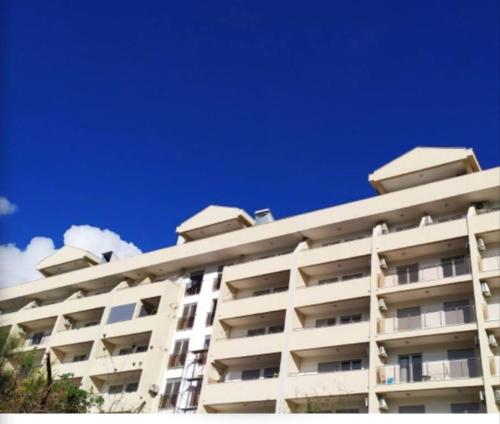a white apartment building with a blue sky in the background at MT One-bedroom boho apartment, Budva in Budva