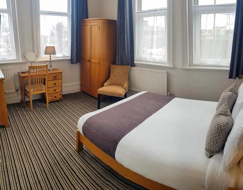 a bedroom with a bed and a chair and a desk at Annabelle Rooms in Great Yarmouth