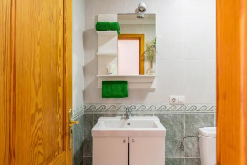 Un baño con lavabo, inodoro y espejo. en Ganivet Home, en Arrecife