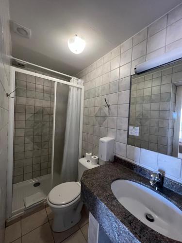 a bathroom with a sink and a toilet and a shower at Hotel La Potiniere in Hyères