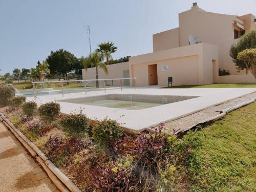- une piscine en face d'une maison dans l'établissement Villanueva Golf- Cozy 2 Bedrooms -Puerto Real, Cádiz, à Puerto Real