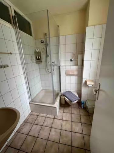 een badkamer met een douche, een bad en een toilet bij Zimmer in Köln in Keulen