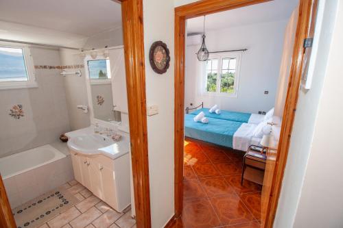 Un baño con una cama, una bañera y un lavabo. en SEA & OLIVES HOUSE, en Lixouri