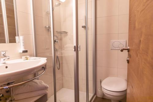 a bathroom with a shower and a toilet and a sink at Appartements Kirchenwirt in Kirchberg in Tirol