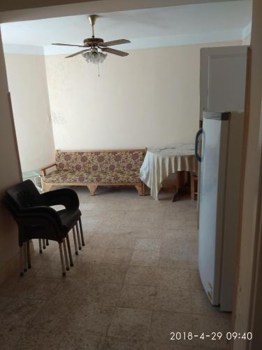 sala de estar con sillas y ventilador de techo en شقه للايجار بيانكي السياحة البيطاش, en Alejandría