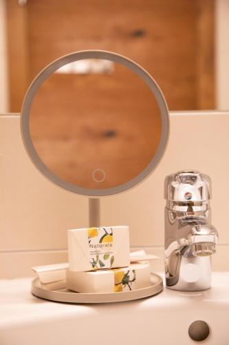 a mirror sitting on a bathroom sink with a cake at Appartements Kirchenwirt in Kirchberg in Tirol
