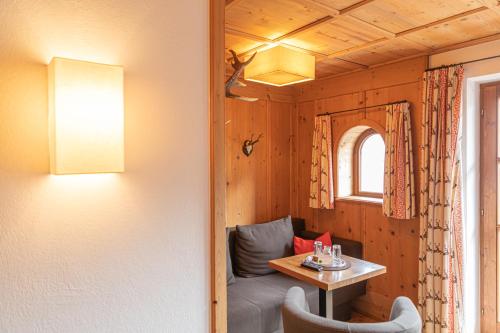 a room with a table and a couch and a window at Appartements Kirchenwirt in Kirchberg in Tirol