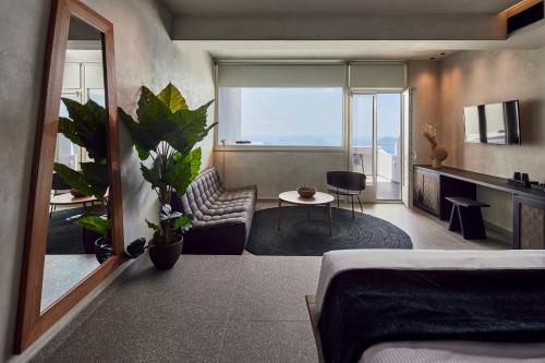 フィロステファニにあるDamigos Caldera Worldのベッドルーム1室(ベッド1台付)、リビングルームが備わります。