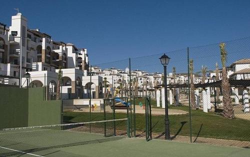 a tennis court with a net in front of buildings at Casa Manuela in Vera